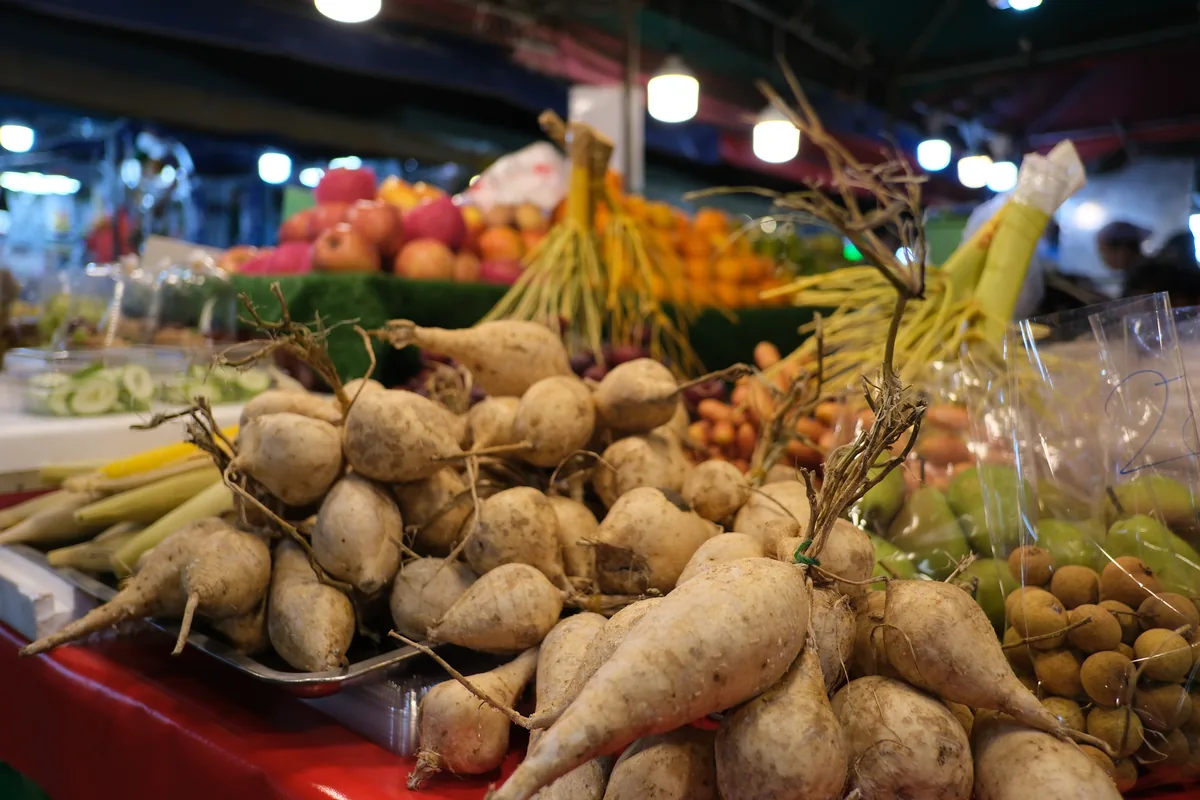 Fresh vegetables and produce piled at a market stall, whole foods that supply essential nutrients